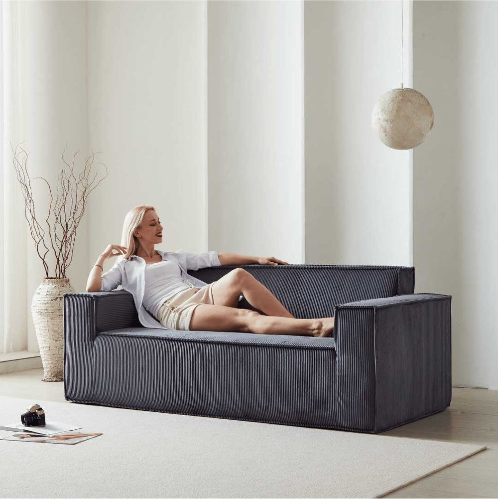 Model lounging on midnight blue Matoresu SignatureLux memory foam couch