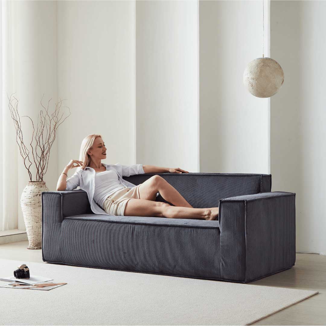 Model lounging on midnight blue Matoresu SignatureLux memory foam couch