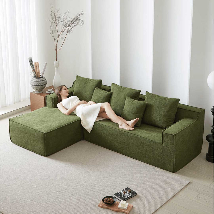 Woman relaxing on Matoresu CloudNest green memory foam sectional chaise sofa in a serene modern living room